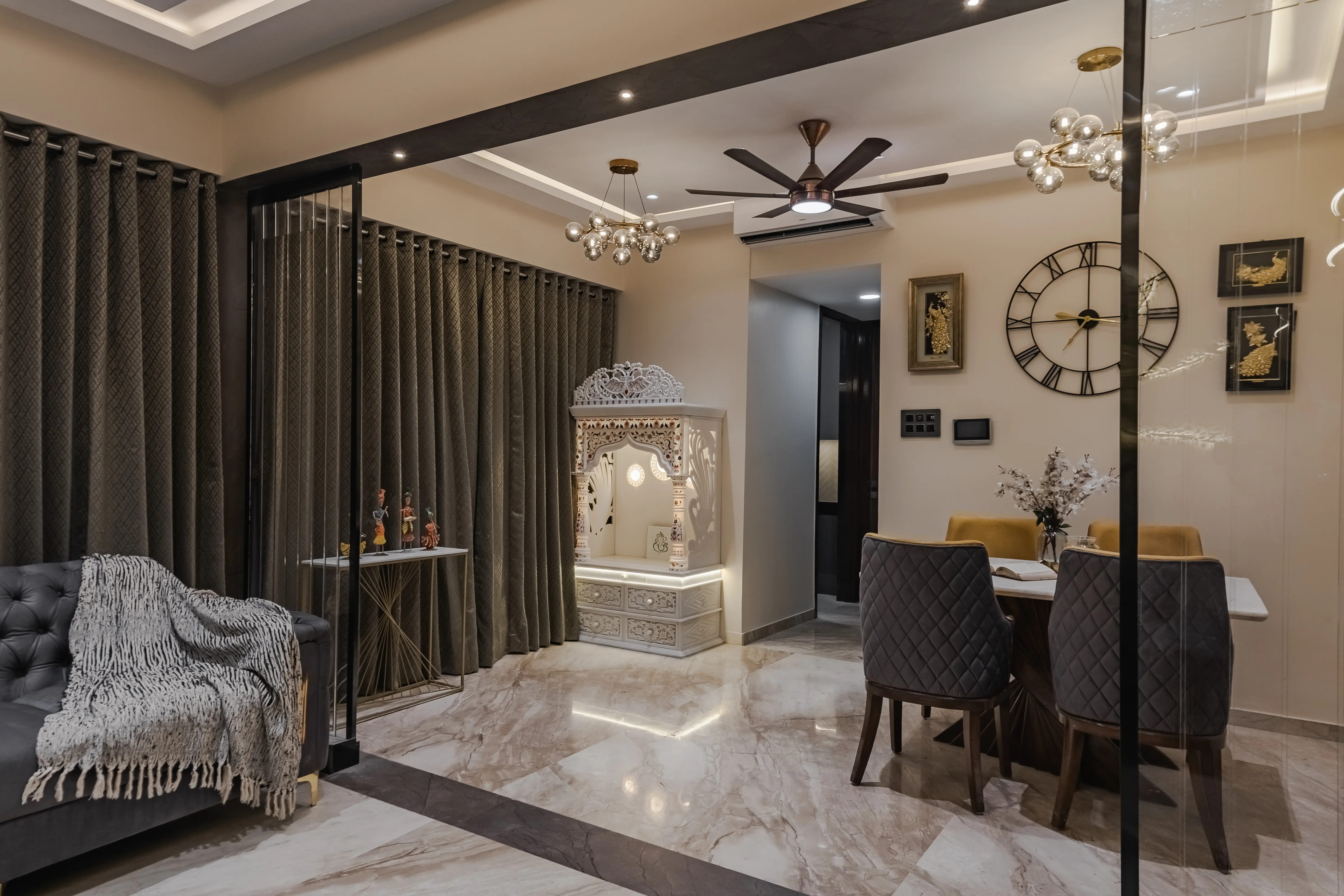 Modern living room in Kandivali features plush L-shaped sofa, round coffee table and patterned rug, interior by Archnine Design Studio