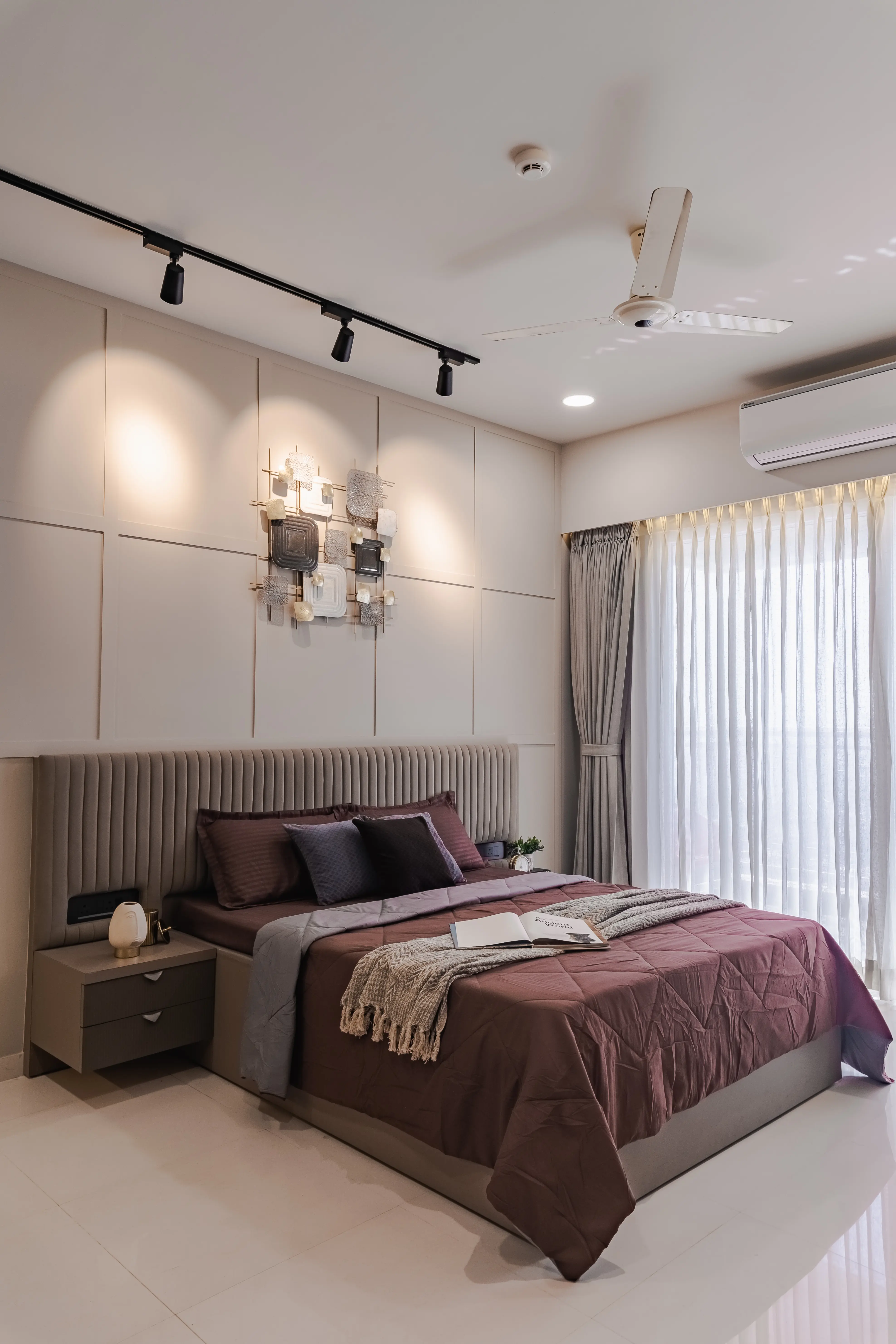 Modern bedroom features, bed and side tables with open book, interior by Archnine Design Studio