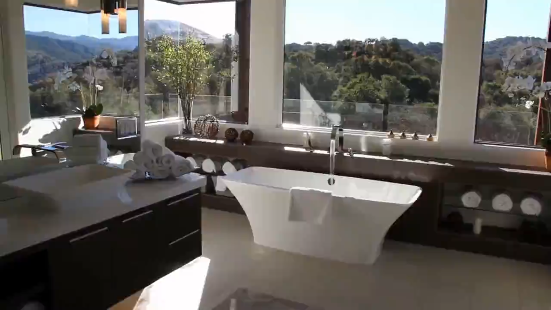 Modern living room design featuring a beige sofa, abstract paintings, and a panoramic view through large windows, interior by Archnine Design Studio